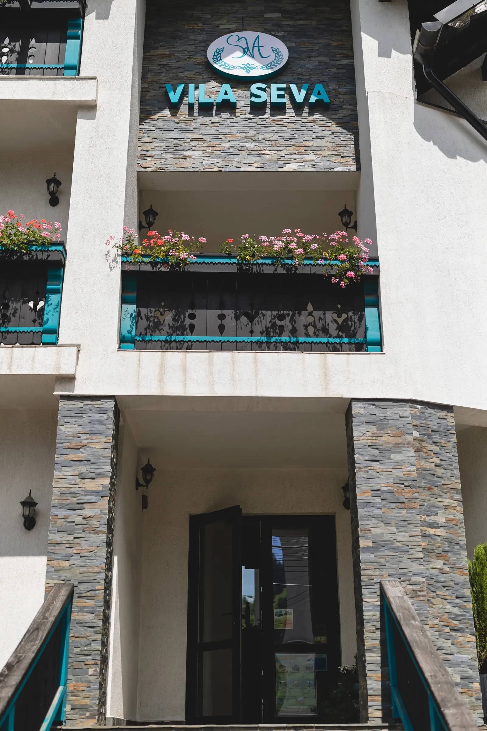The entrance of Vila Seva, with the sign on the stone wall